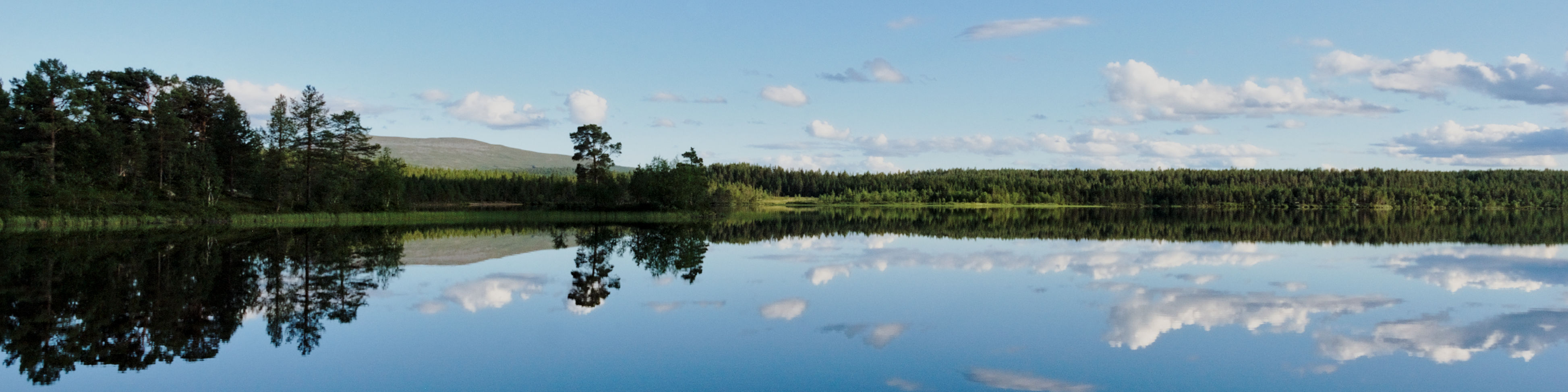 blue lake with fell in background and clouds mirroring in the water