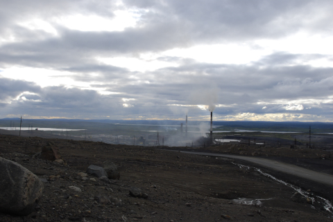 tuhoutunut maisema ja tupakoiva kaivoslaitos