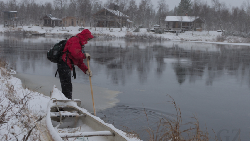 kanootti lumipeitteisen joen rannalla
